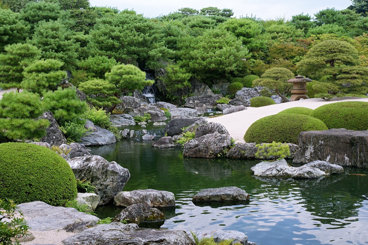 足立美術館池庭 —— 庭深處的瀑口之水曲折流入前方大池，石材為鳥取縣名產佐治石