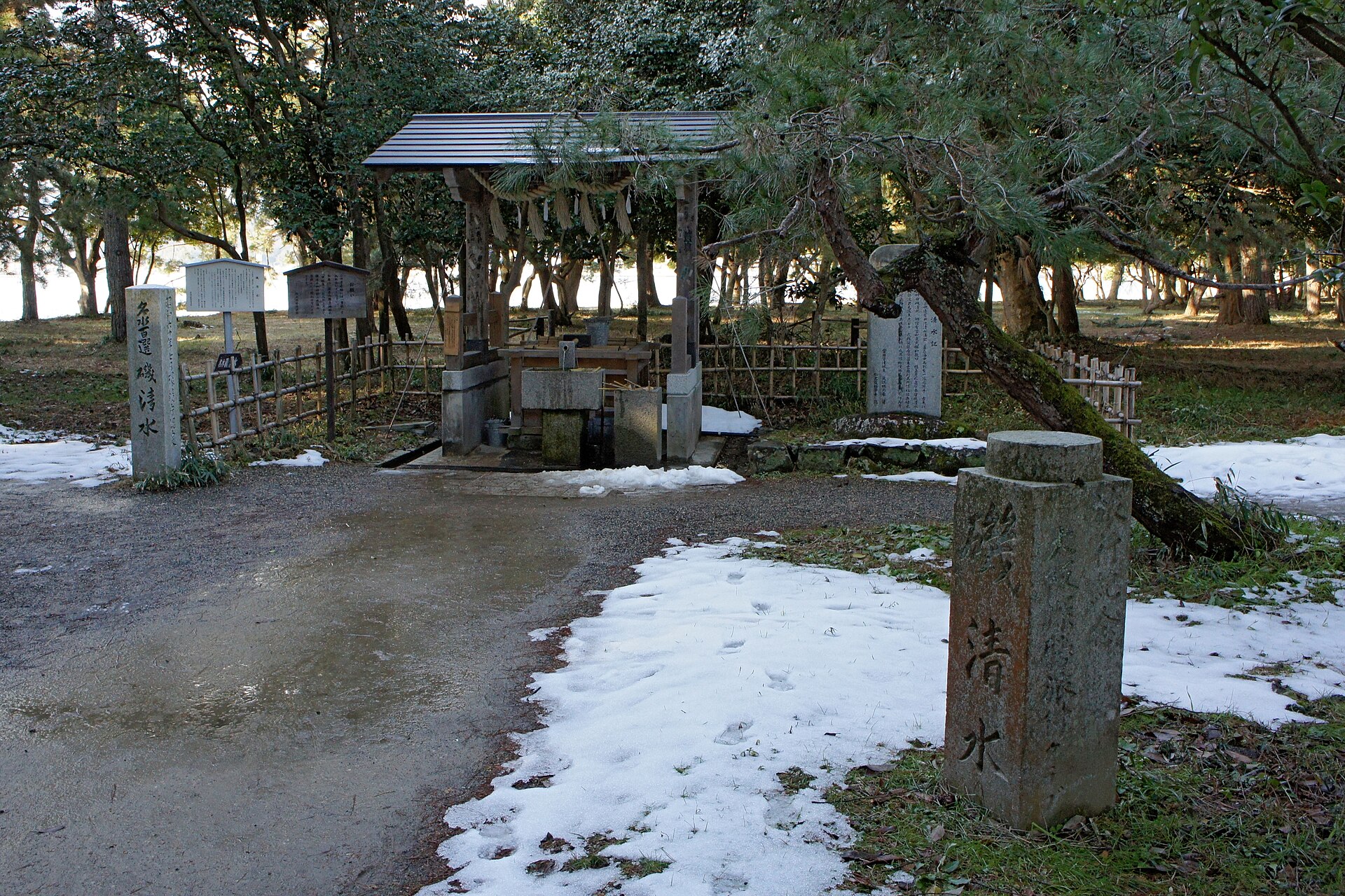 天橋立砂洲中央的「磯清水」湧泉，木造小屋頂下是取水口，右前方立著刻有「磯清水」的石碑