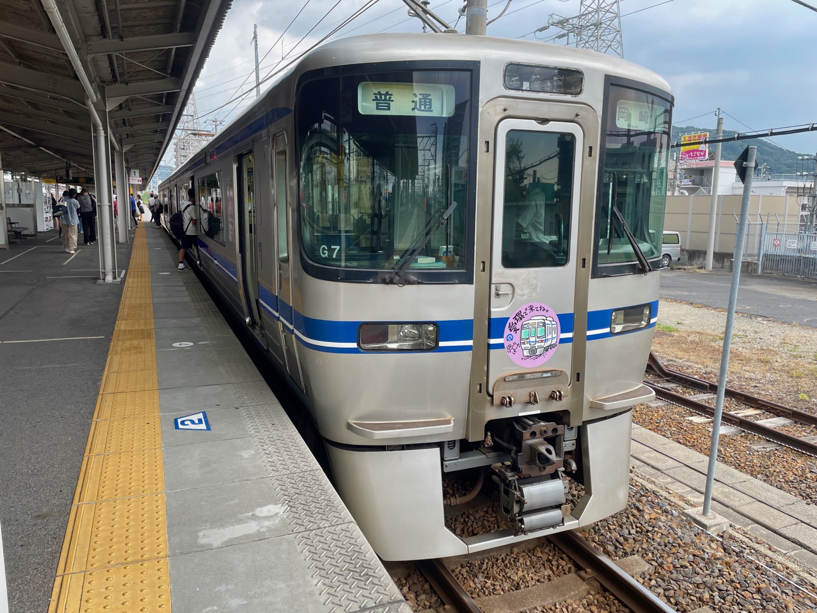 愛知環狀鐵道（愛知環状鉄道）普通列車停靠月台 — 車頭掛有「ジブリパーク愛環で来てね」吉卜力公園宣傳標識