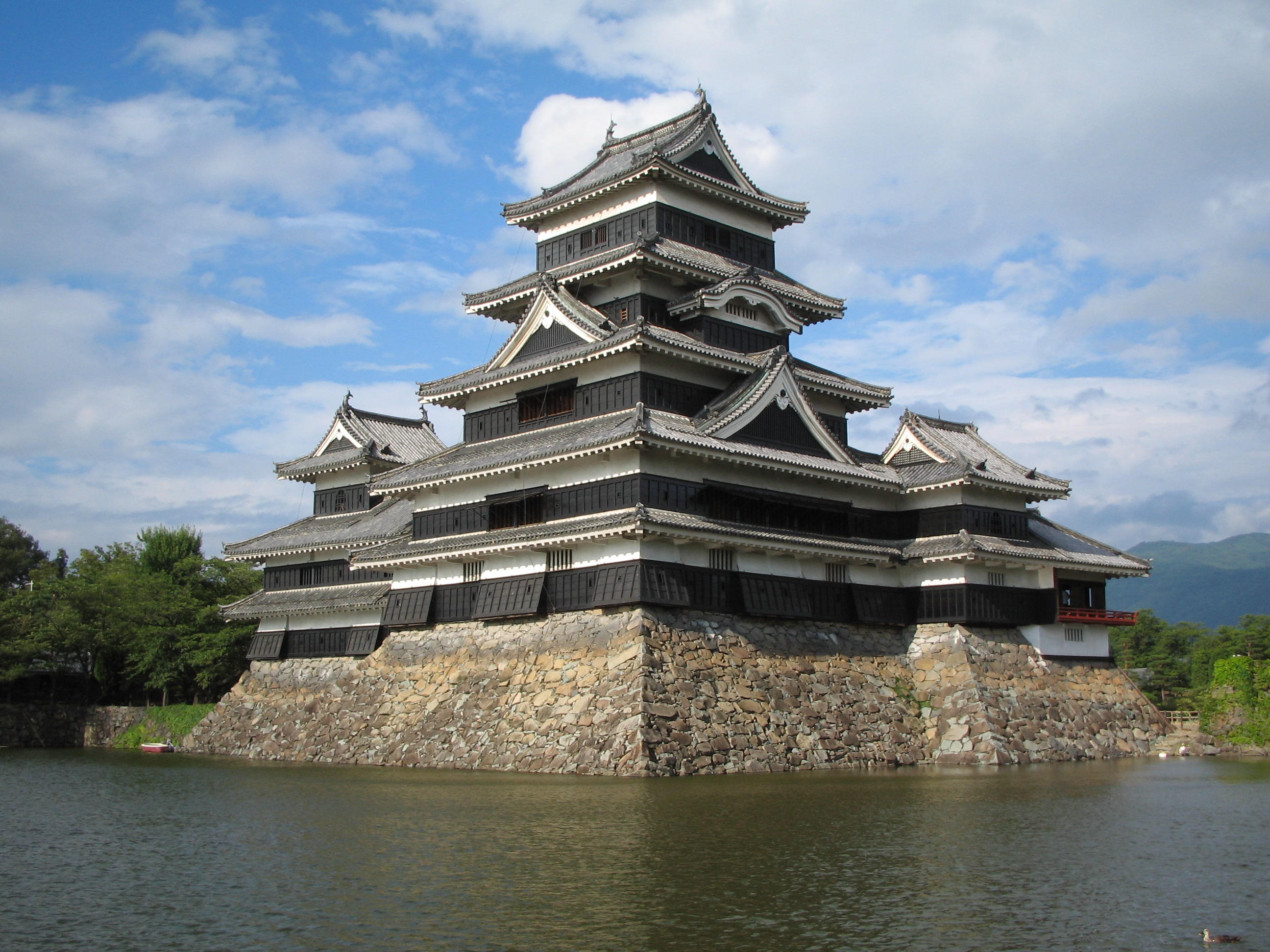 松本城天守閣近景，黑色木造外牆與白色漆喰的對比