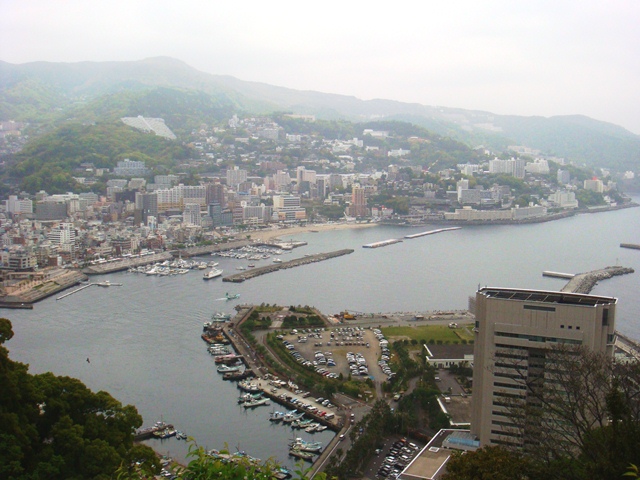 從山頂俯瞰熱海市區，溫泉飯店林立、海岸線與相模灣全景