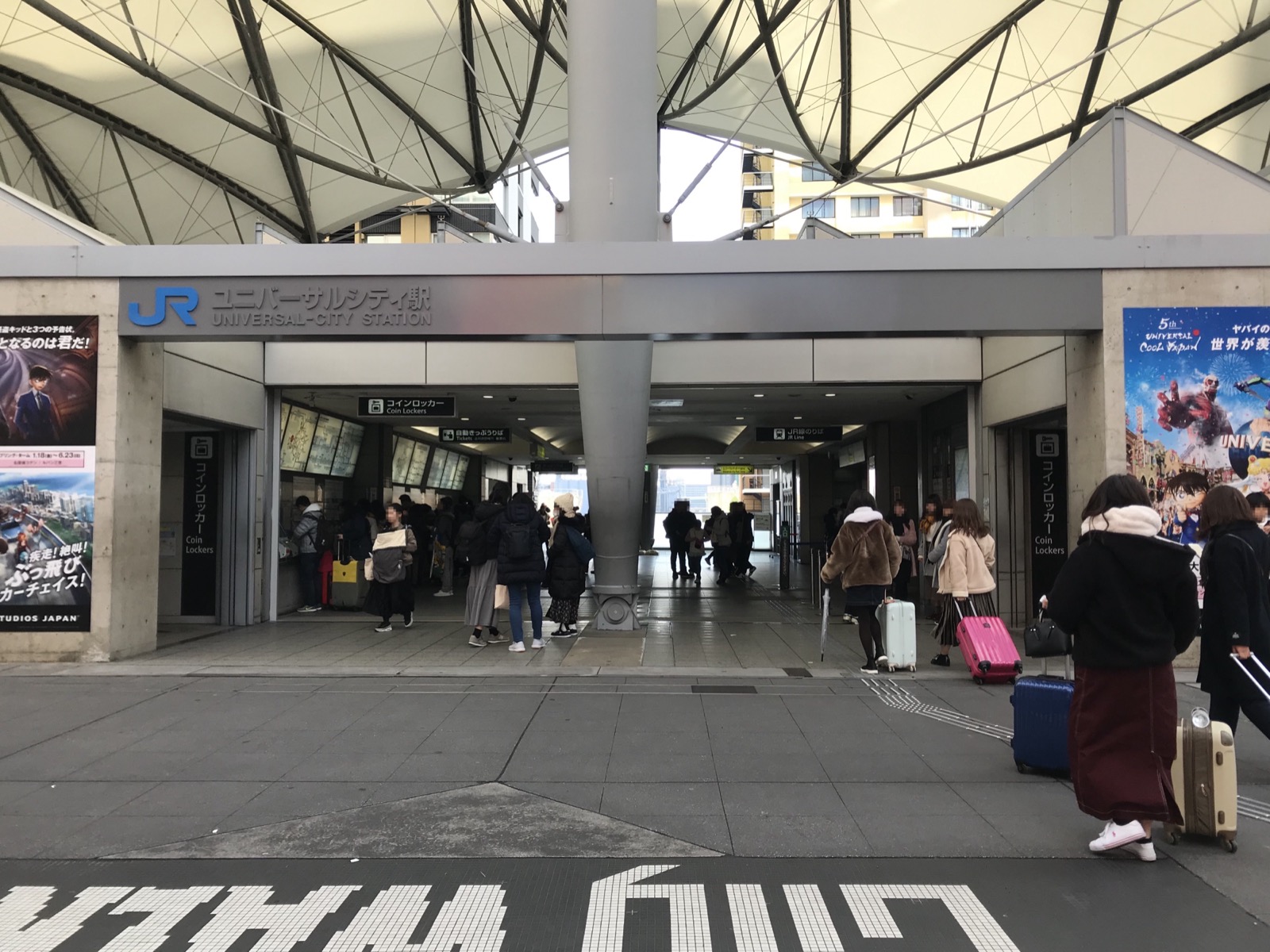 JR 夢咲線（櫻島線）ユニバーサルシティ駅入口——藍底白字的「JR ユニバーサルシティ駅」站名標識與帳篷狀屋頂，是前往大阪環球影城 USJ 的最近車站